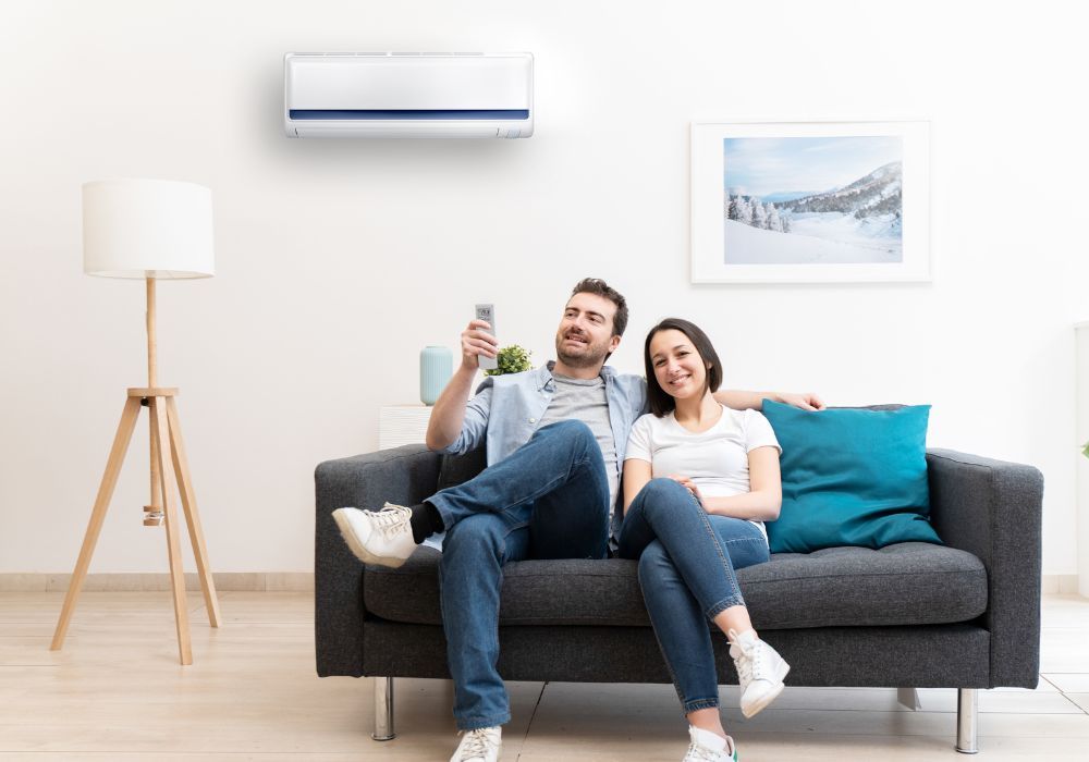Couple enjoying AC Machine in their living room with a remote